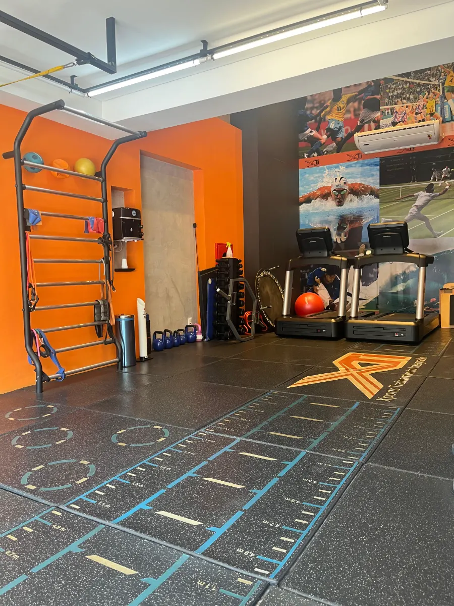 Área de treinamento do Studio XTI, com espaldar, esteiras e piso demarcado